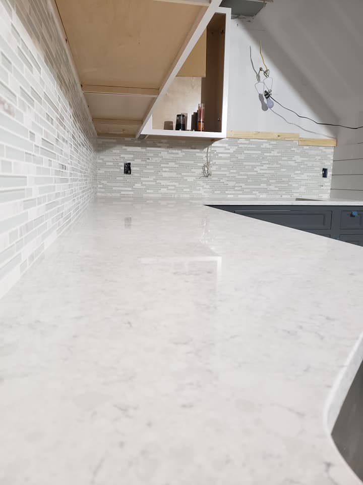 White glass and porcelain interlocking mosaic backsplash above kitchen counter