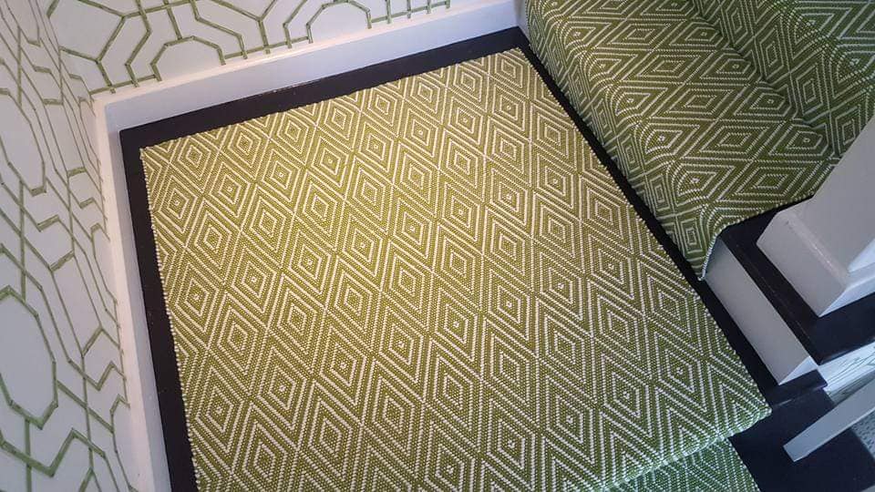 Close up of green and white diamond runner on stair landing