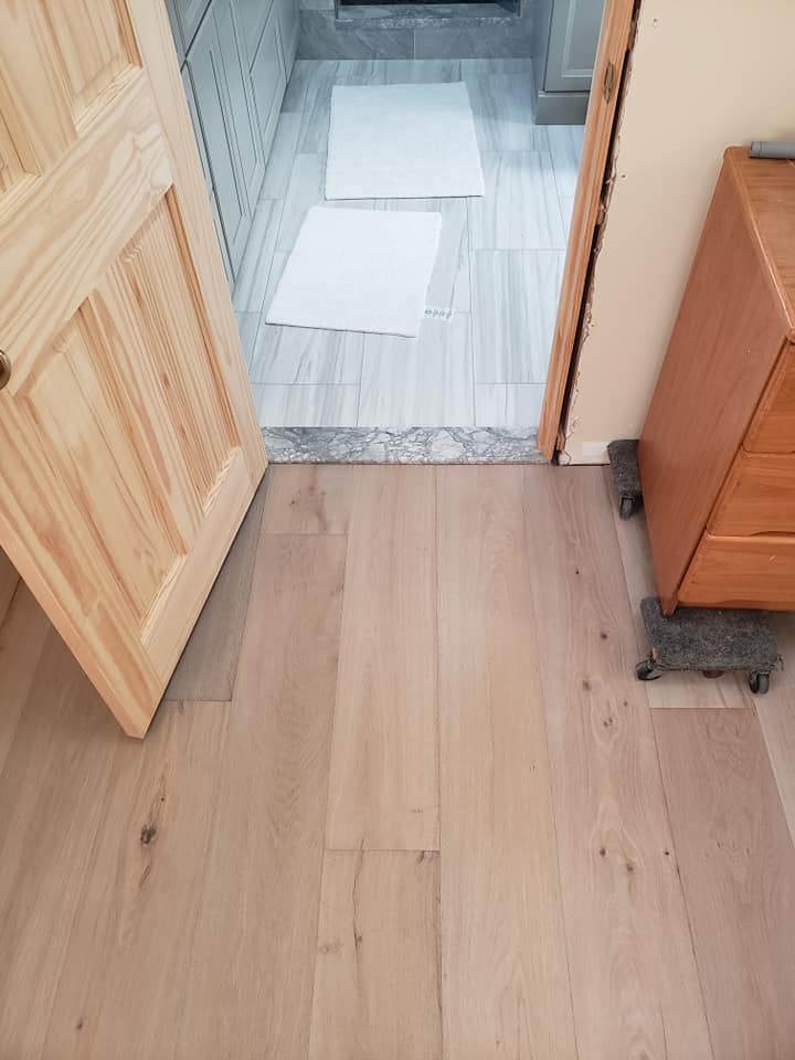 Natural wood floor against gray wood tile for bathroom