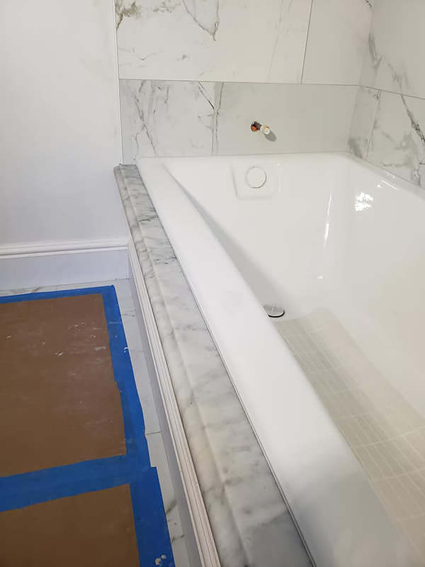 White tub and marble tub deck installed