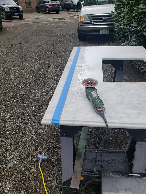 Cutting marble with wet saw for tub deck in custom shower