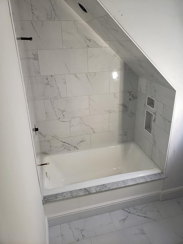 Angled shower tile and tub installed before shower fixtures installed