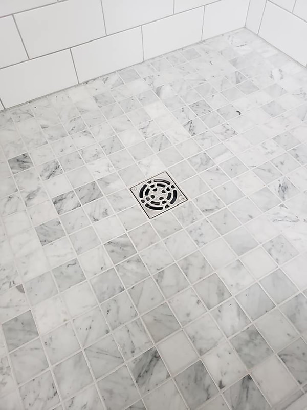 Checkered marble tile shower floor detail with shower drain