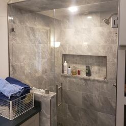 Complete custom tile shower with shower niche and glass doors